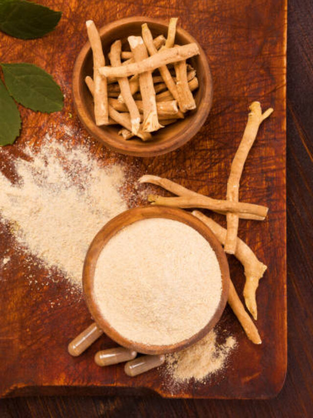 Ashwagandha superfood powder and root on cutting board on wooden table.