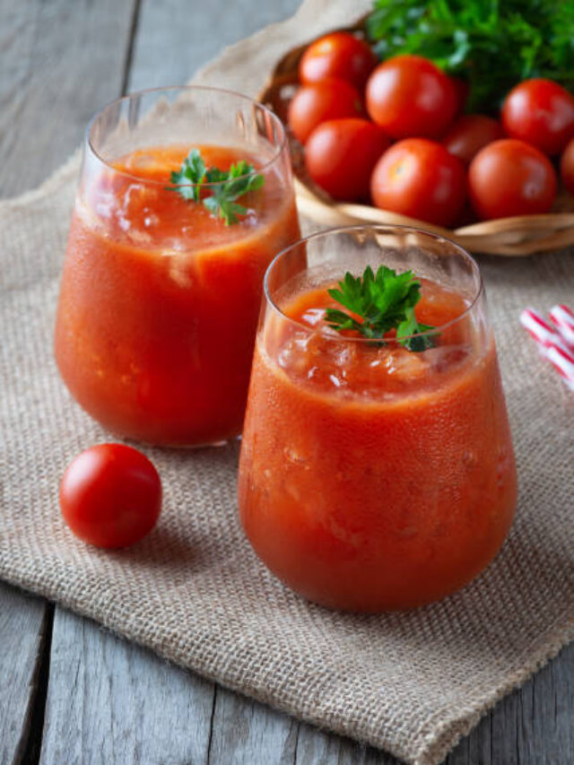 Tomato juice with ice in a glass, parsley and tomato on sacking.