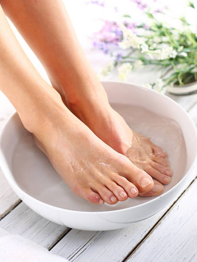 A woman washes the feet in a bowl of water and salt to the foot