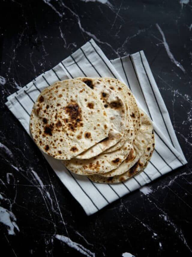 Pan roasted pita bread on dark background. Top view. High quality photo